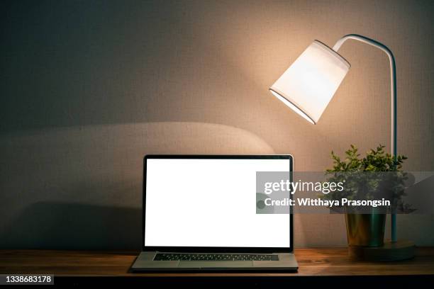 laptop on wooden table at night. - schreibtisch laptop tablet stock-fotos und bilder