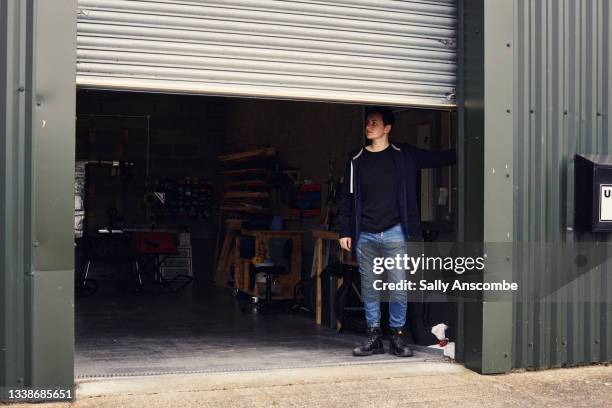 female entrepreneur opening shutters to her workshop - shutter stock pictures, royalty-free photos & images