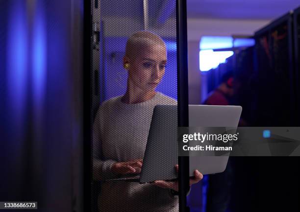shot of a young female engineer working in a server room - woman coding stockfoto's en -beelden