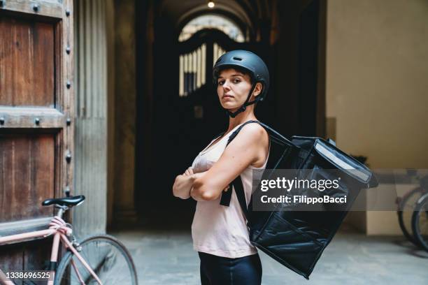 porträt einer jungen erwachsenen entbindungsfrau, die in die kamera schaut - bike messenger stock-fotos und bilder