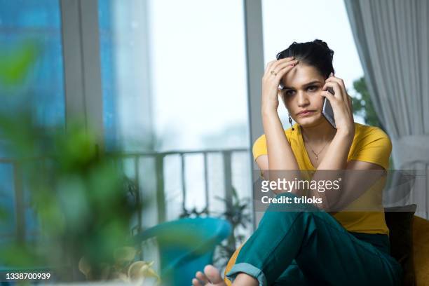 sad woman talking on mobile phone - female worried mobile imagens e fotografias de stock