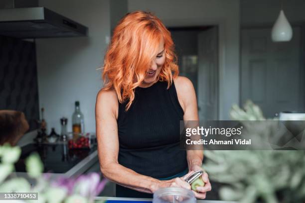pilates instructor preparing a smoothie - older woman colored hair stock pictures, royalty-free photos & images