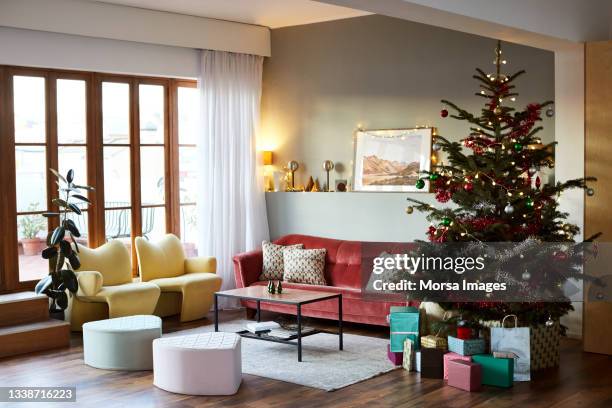 christmas tree and furniture in living room - living room stock-fotos und bilder