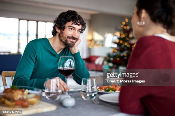 smiling man with woman at dining table - verliefd worden stockfoto's en -beelden