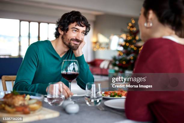 smiling man with woman at dining table - casal romântico imagens e fotografias de stock