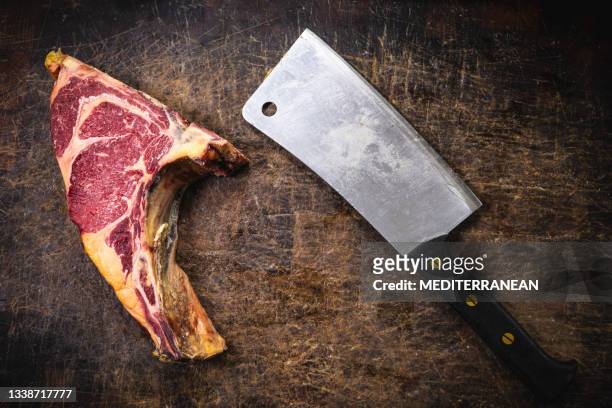 butcher meat cleaver and dry-aged beef veal steak meat fillet on chopping table - beef ribs stockfoto's en -beelden