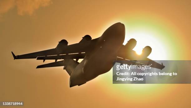 a large us military transport plane took off in the setting sun - air freight transportation stock pictures, royalty-free photos & images