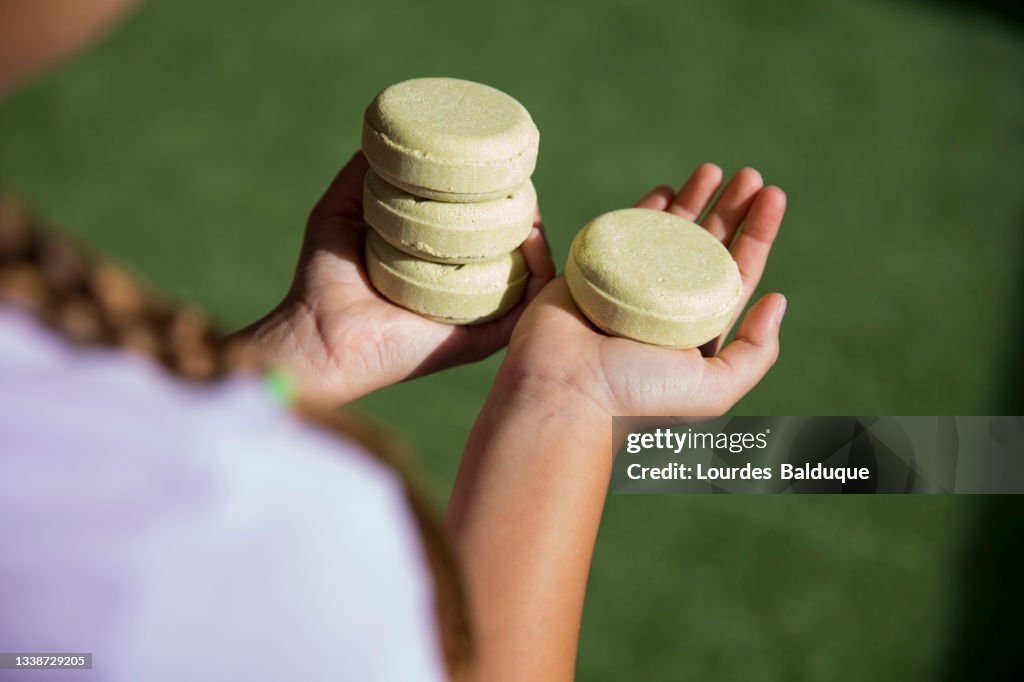Stack of organic soap and shampoo in hands