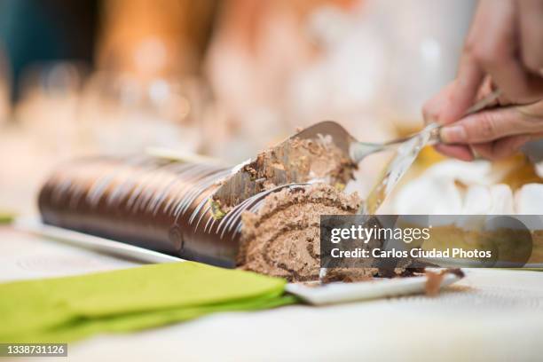cutting chocolate cake with stainless steel pie servers - blurry living room stockfoto's en -beelden