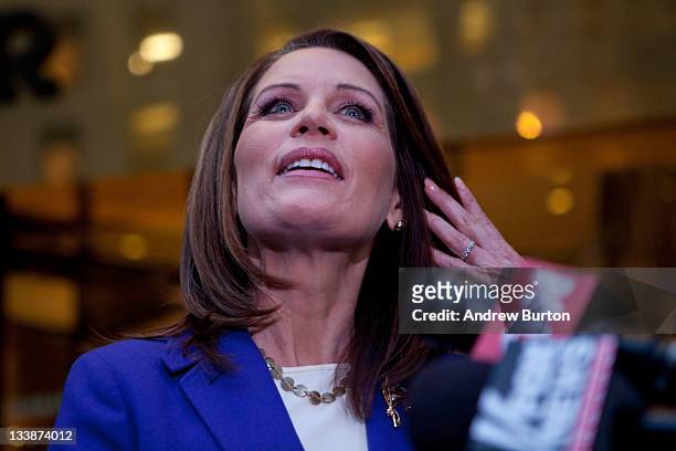 Republican presidential candidate U.S. Rep Michele Bachmann wipes hair from her face while speaking to members of the media after meeting with Donald...