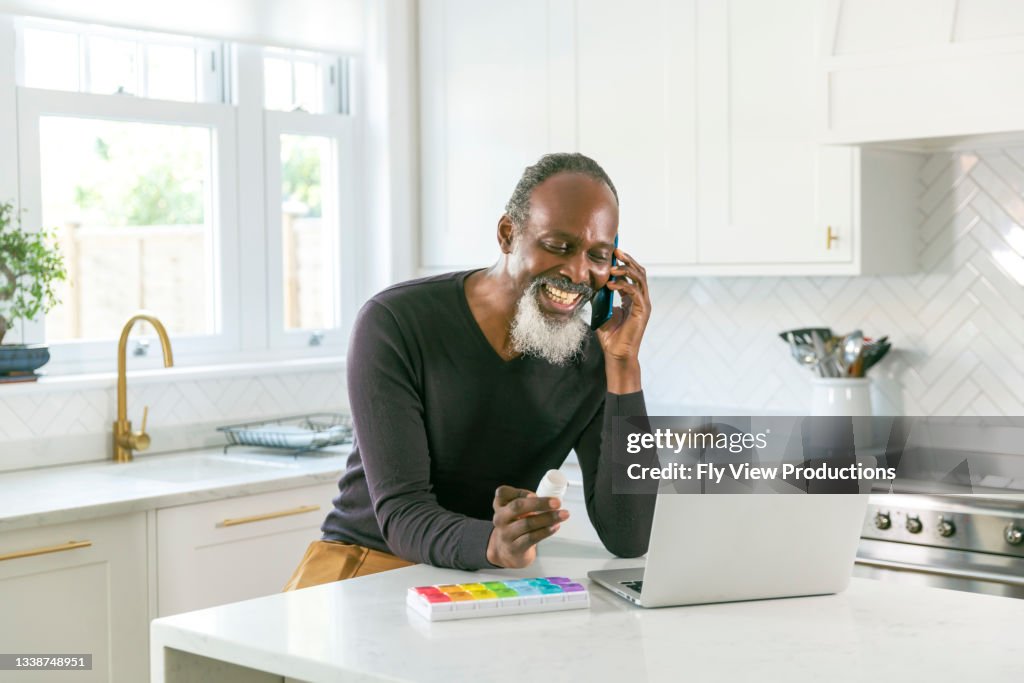 Senior black man speaking on the phone with his doctor about prescription medication