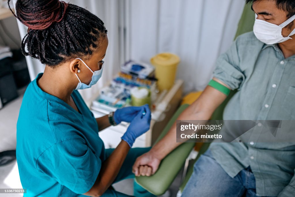 Nurse preparing patient to do a blood analysis