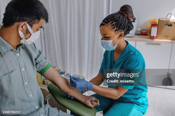 infirmière préparant le patient à faire une analyse de sang - prise de sang photos et images de collection