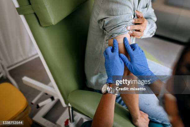 putting band aid on after vaccination - wereldwijde gezondheid stockfoto's en -beelden