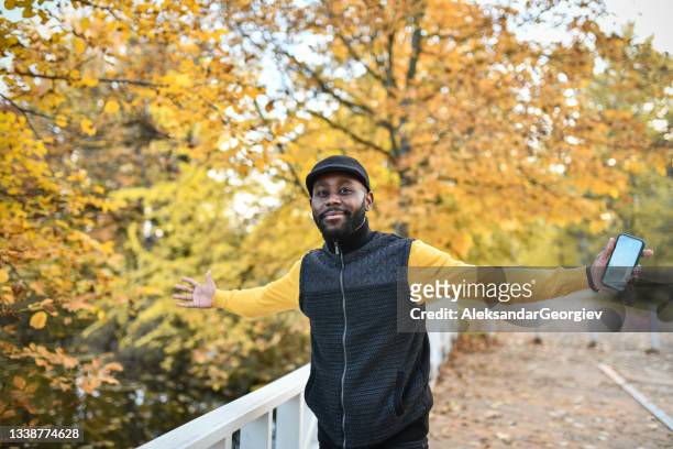アフリカの男性は、公園の外で秋と自由の色を楽しんでいます - african american couple walking park ストックフォトと画像