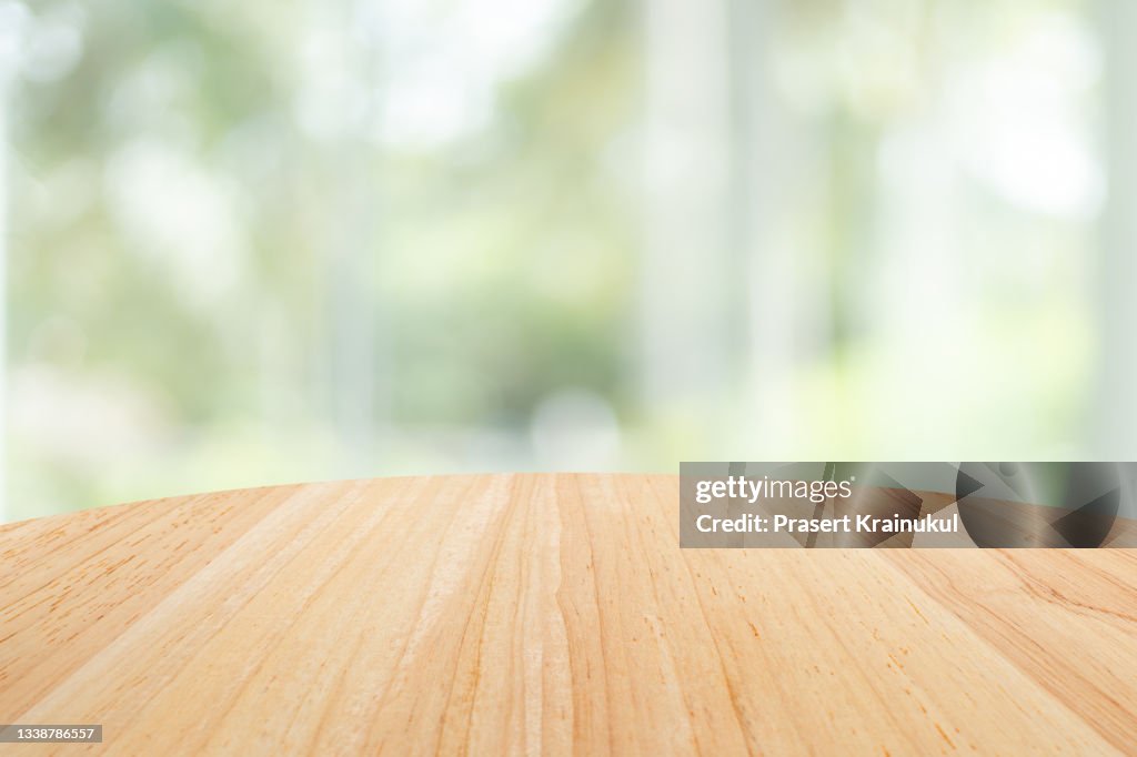 Empty round wood table top and blur glass window wall building. Banner mock up abstract background