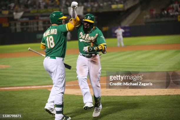 Josh Harrison of the Oakland Athletics celebrates with Mitch Moreland after hitting a home run during the game against the New York Yankees at...