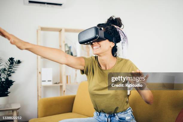 porträt eines mädchens, das zu hause 3d-spiele spielt - vr goggles woman stock-fotos und bilder