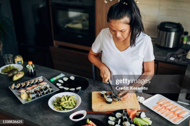 thai sushi master cutting the traditional sushi rolls into one bite pieces on the cutting board - shrimp edamame stock pictures, royalty-free photos & images