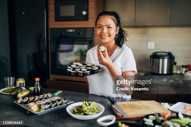 woman thai ethnicity can't hide the smile on her face while showing her perfect sushi rolls - shrimp edamame stock pictures, royalty-free photos & images