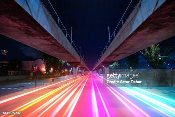 colorful light trails flowing in the city connecting urban spots. visualizing 5g. - symmetrie stockfoto's en -beelden