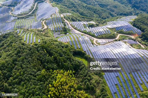 a bird's eye view of the solar power plant and lush woods on the top of the mountain - lush plants stock pictures, royalty-free photos & images