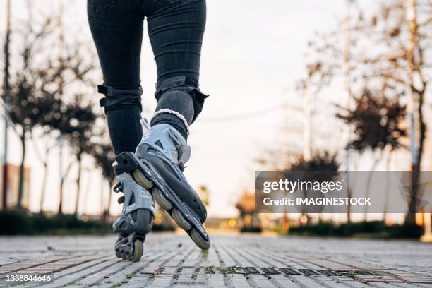 view from behind of woman inline skater - inline skating fotografías e imágenes de stock