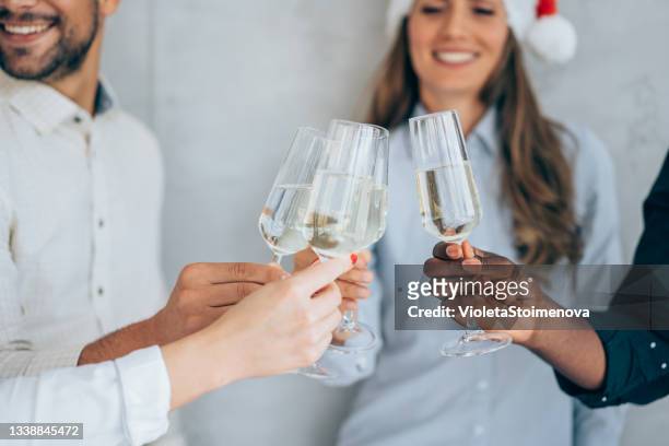 fröhliches business-team beim anstoßen mit champagner während der weihnachtsfeier im büro. - christmas party office stock-fotos und bilder