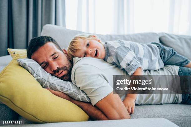 father and little son at home. - sleeping stock pictures, royalty-free photos & images