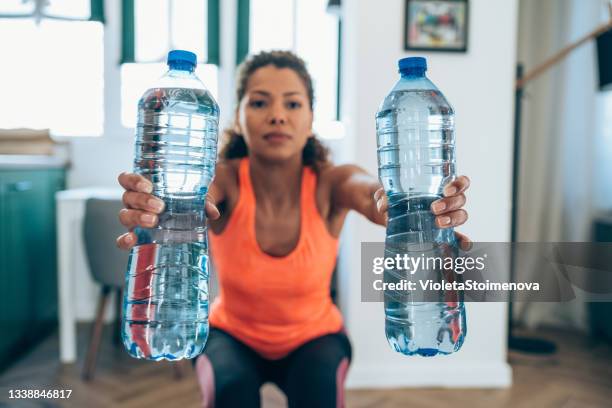 frauentraining zu hause mit wasserflaschen. - gallone stock-fotos und bilder