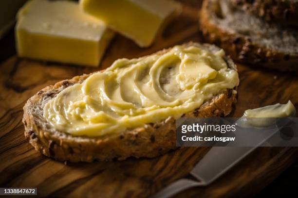 beurre étalé sur une tranche de pain - margarine photos et images de collection