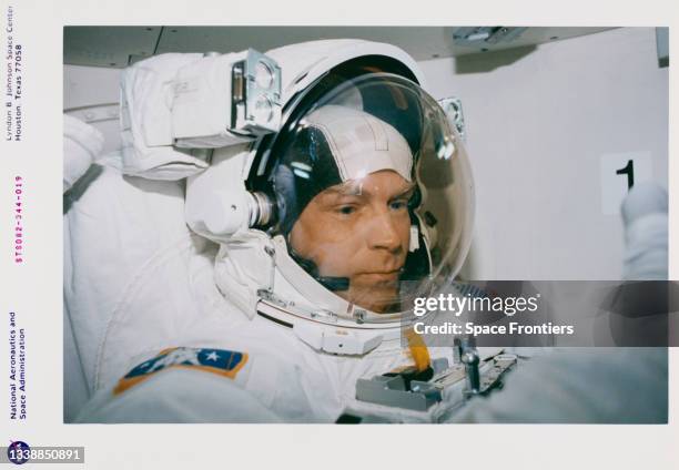 Attired in the Extravehicular Mobility Unit spacesuit, astronaut Mark C Lee, payload commander, is in the airlock Discovery preparing for one of five...