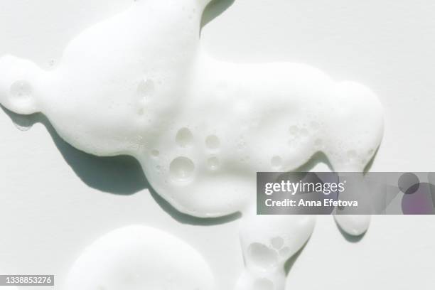 smears of white foam on white background. facial cleanser for perfect skin. macrophotography in flat lay style - white colour swatches stock pictures, royalty-free photos & images