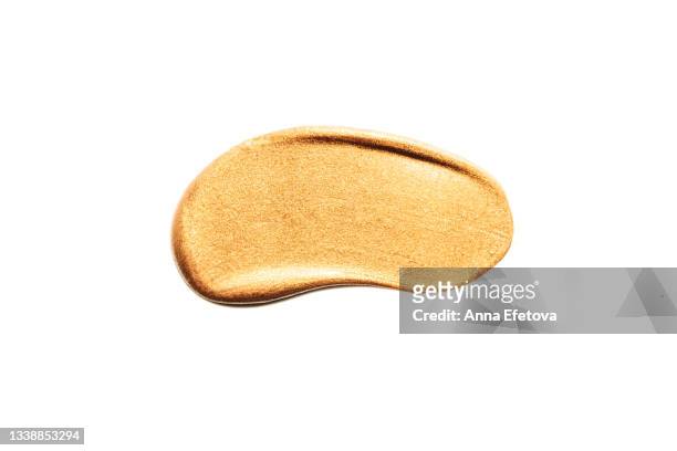 textured smear of gold eyeshadows with glittering particles. body lotion with shimmer or sunscreen oil for perfect tan. macrophotography in flat lay style - highlighter stock-fotos und bilder