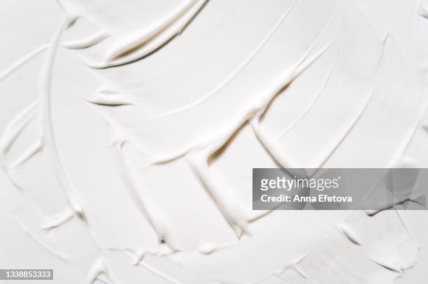 background made with textured smears of white cream. body lotion for perfect skin. copy space for your design. macrophotography in flat lay style - spatula stock pictures, royalty-free photos & images