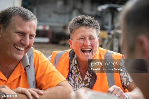 female business owner relaxing with coworkers at lumberyard - lunch break stockfoto's en -beelden