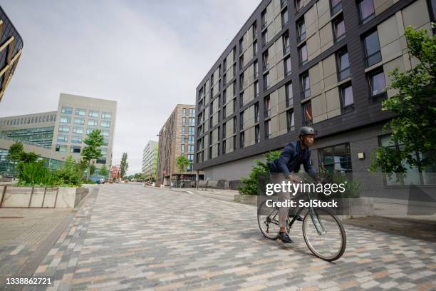 commuting businessman riding his bicycle in the city - carbon neutrality stock pictures, royalty-free photos & images