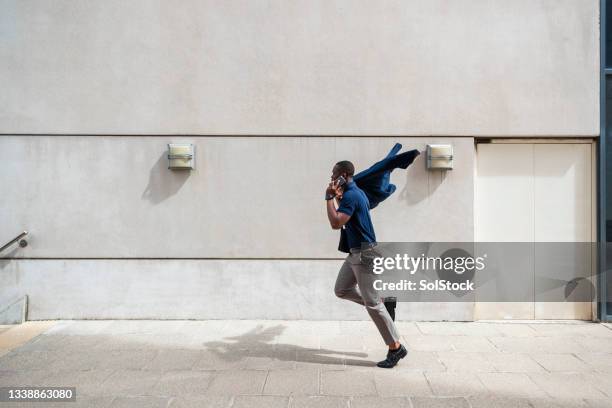 businessman using phone as he commutes to work - man walking side view stock pictures, royalty-free photos & images