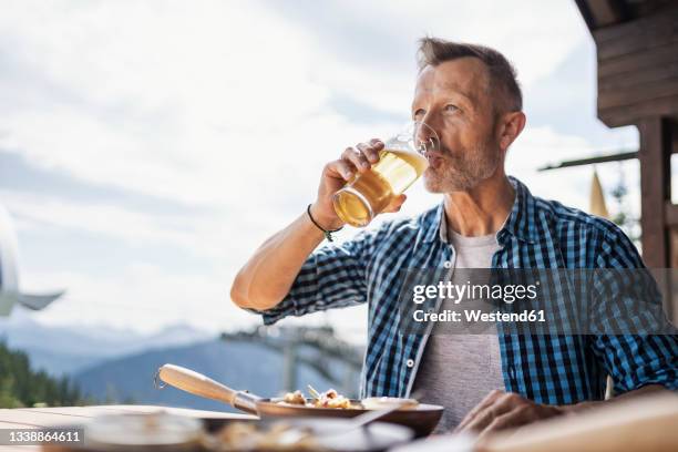 man drinking beer while sitting at restaurant - kaiserschmarrn stock pictures, royalty-free photos & images