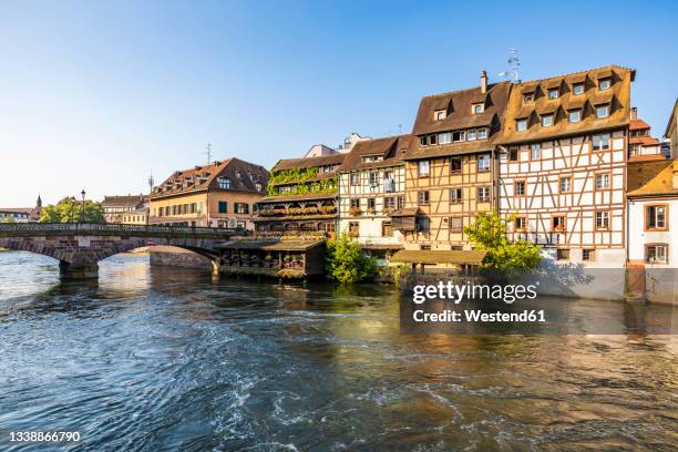 france, bas-rhin, strasbourg, ill river canal with arch bridge and half-timbered townhouses in background - strasbourg stock pictures, royalty-free photos & images