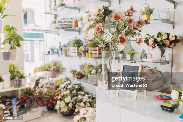 sign board kept by flower vase at checkout in flower shop - floristería fotografías e imágenes de stock