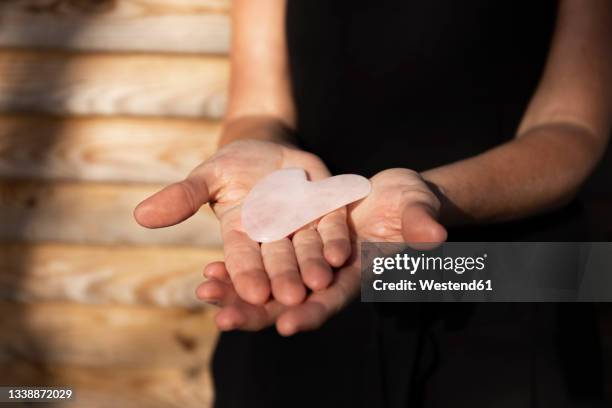 masseuse holding pink gua sha tool - spooning stock pictures, royalty-free photos & images