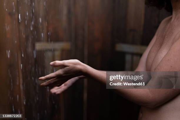 shirtless woman taking shower in cabana - middle age imagens e fotografias de stock