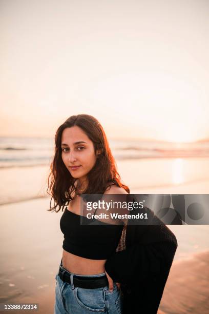 young woman on shore at beach during sunset - teenager staring imagens e fotografias de stock