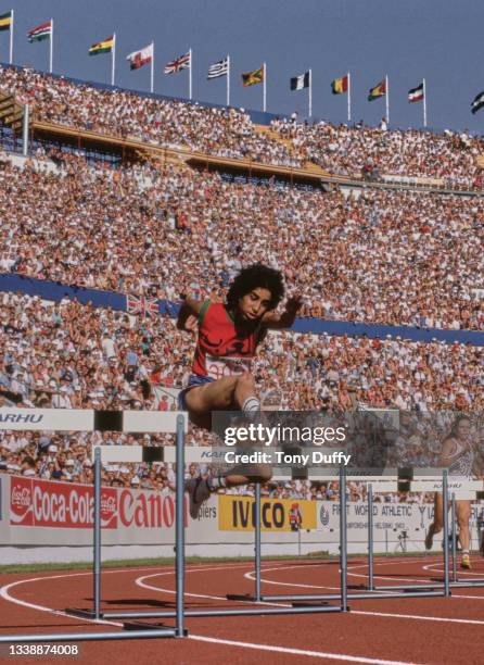 Nawal El Moutawakel of Morocco clears a hurdle during Heat 2 of the Women's 400 metres Hurdles event at the inaugural International Association of...