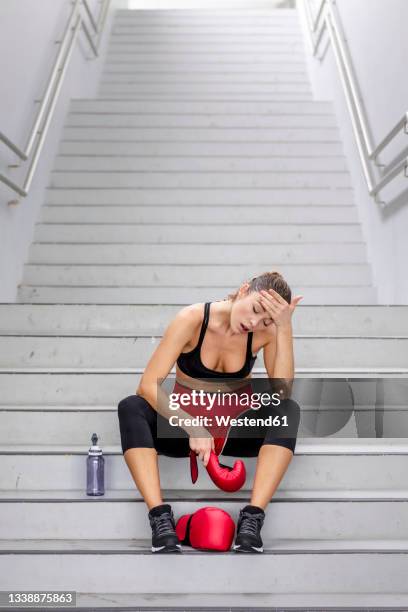 tired female boxer sitting on steps - female boxer ストックフォトと画像