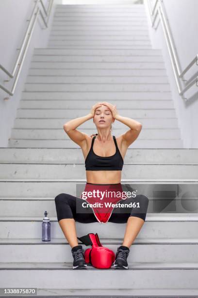 female boxer with head in hands sitting on staircase - female boxer ストックフォトと画像