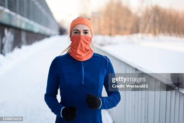 young woman in gaiter face mask near railing during winter - luva roupa desportiva de proteção imagens e fotografias de stock