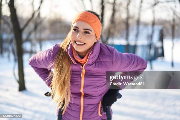 smiling woman in warm clothing during winter - ダウンジャケット ストックフォトと画像