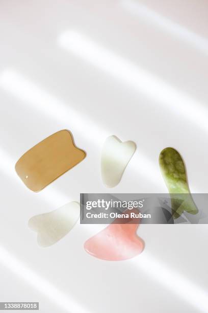 gua sha scrapers on white background. - jade gemstone stockfoto's en -beelden